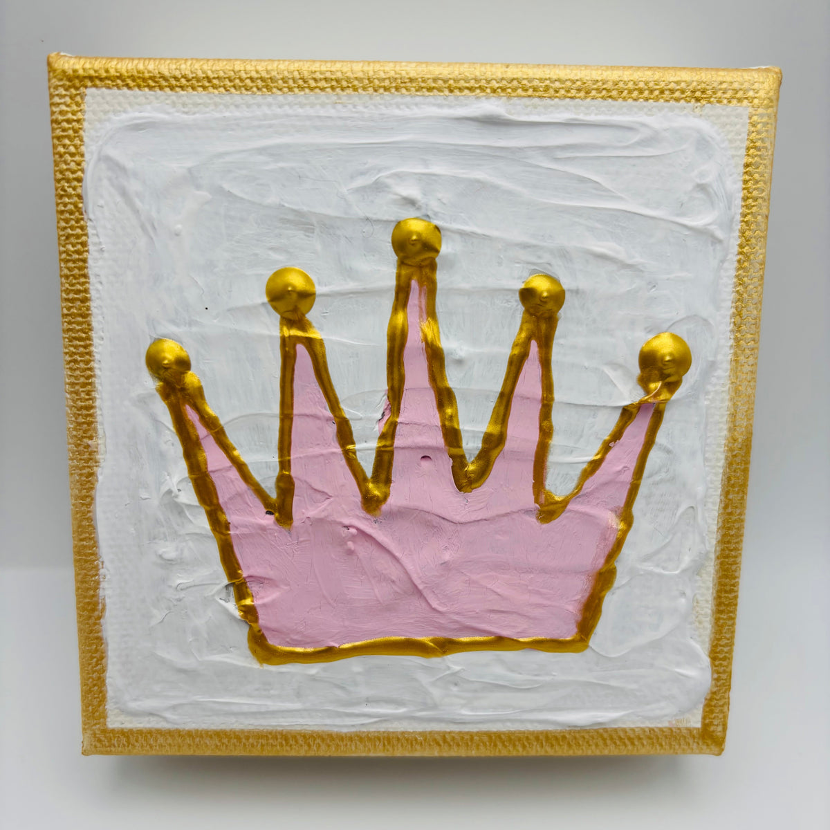 A square decorative art piece featuring a textured pink crown outlined in gold, set against a white background with a gold border.