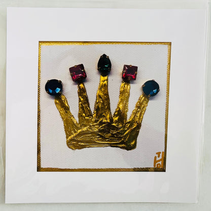 Two square white art prints displayed side-by-side on a light gray marble surface. Each print features a textured, crumpled gold crown with faceted gems on a thin gold border.