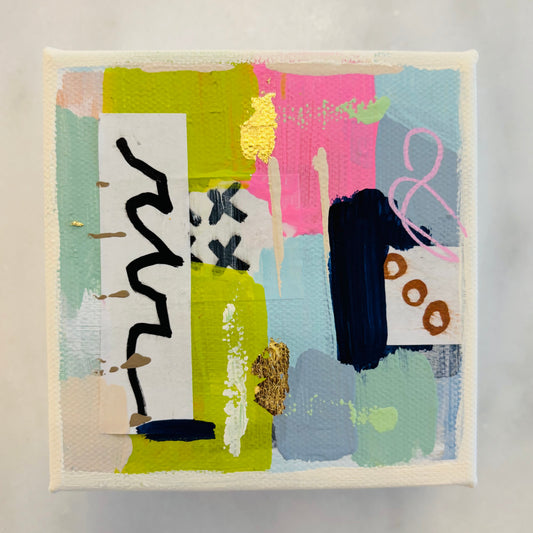 A square abstract canvas painting with textured brushstrokes in pastel pink, light blue, mint green, olive yellow, black, and white, featuring gold leaf accents, displayed on a light marble surface.
